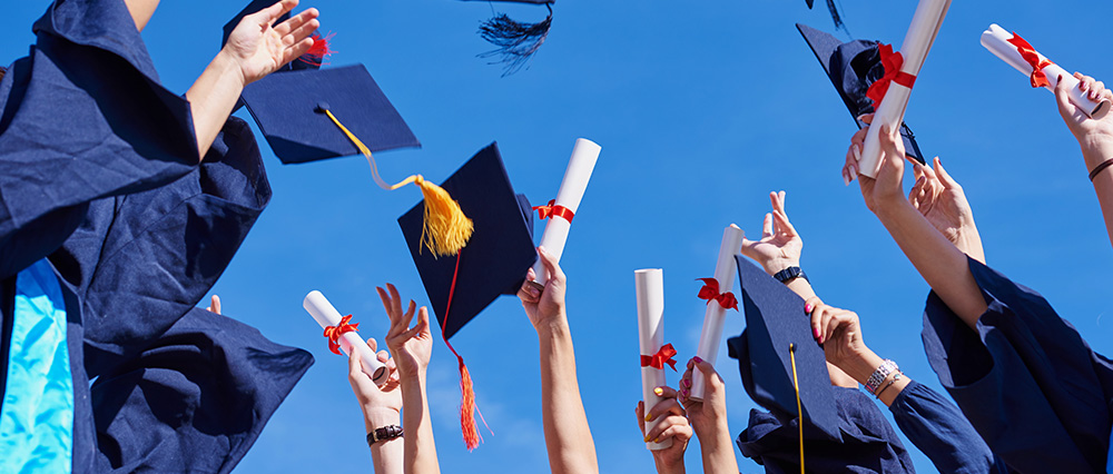 Graduates throwing hats in air